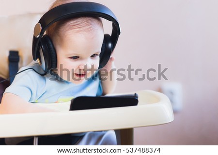 child listening to music on headphones at home