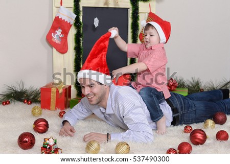 Father and son play with Christmas decorations on New Year and opening gifts
