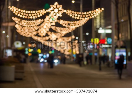 Blurred background of christmas street lights with people silhouettes in Vienna, Austria
