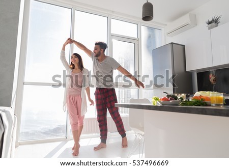 Young Couple Dancing In Kitchen, Lovely Asian Woman And Hispanic Man Modern Apartment With Big Windows Interior Royalty-Free Stock Photo #537496669