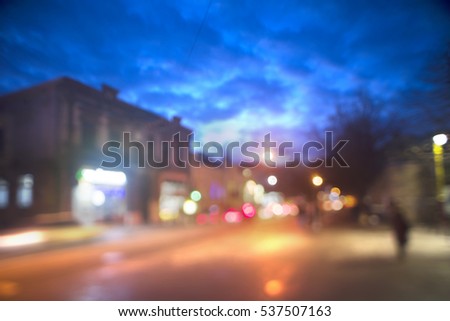 Evening city picture with defocused effect blur Lenses gives lightness and fabulousness. Illumination and fabulous silhouette of people going shopping for Christmas