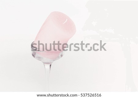 Pink melted candle on a glass support