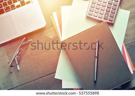 Notebook with calculator, keyboard and pen on table