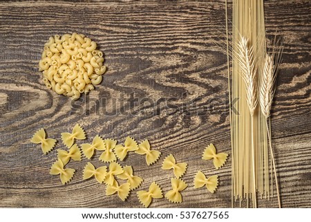 Pasta,  spaghetti and wheat on a wooden background. Bright and cheerful picture.