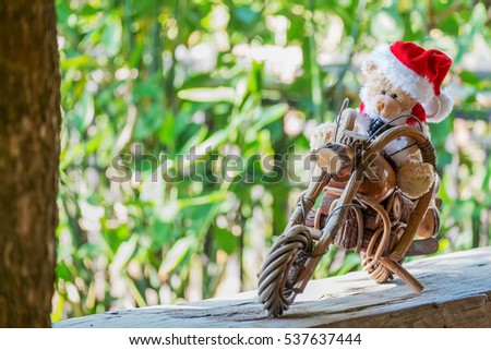 a teddy bear drive a wood motorcycle.dressed as santa claus.
