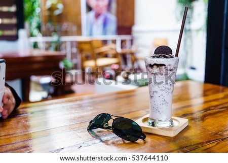 Milkshake with cookies and cream frappe on wood table in cafe