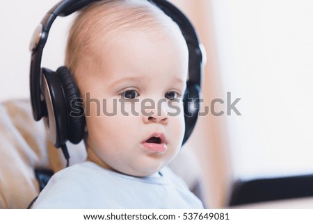 child listening to music on headphones at home