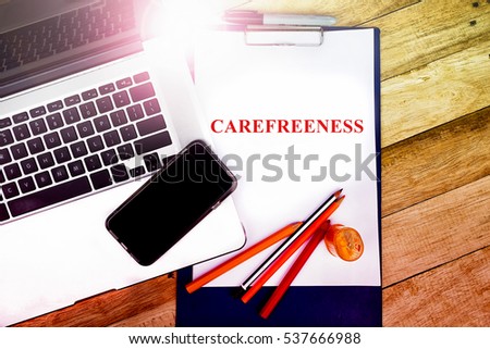 CAREFREENESS  word, text write at notepad in wooden background. typography concepts.

