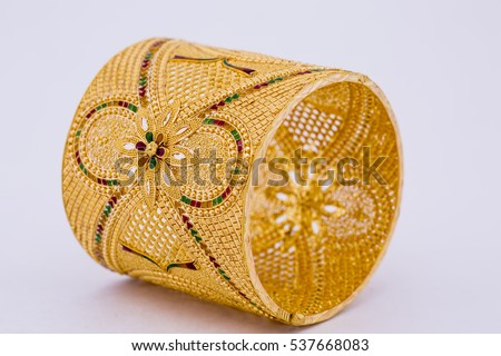 Indian style beautiful floral gold bangle isolated on white background. Gold jewellery stock photo. Royalty-Free Stock Photo #537668083