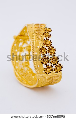 Beautiful floral gold bangle isolated on white background. Gold jewellery stock photo. Royalty-Free Stock Photo #537668095