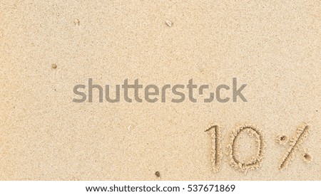 Handwriting words "10%" on sand of beach