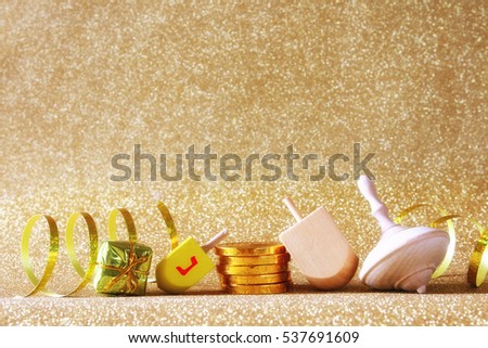 Image of jewish holiday Hanukkah with wooden dreidel (spinning top) on the glitter background