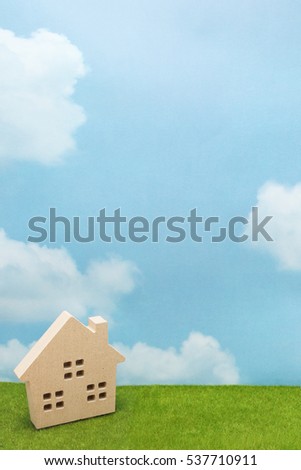 House on green grass over blue sky and clouds. Mortgage concept.