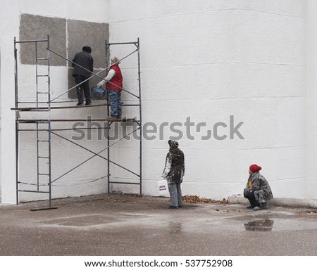 The builders are painting the building              