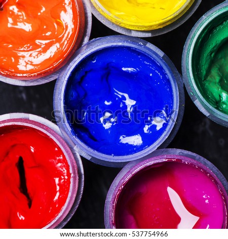 Bright multi-colored paint on  black wooden background.  for the artist. Education.