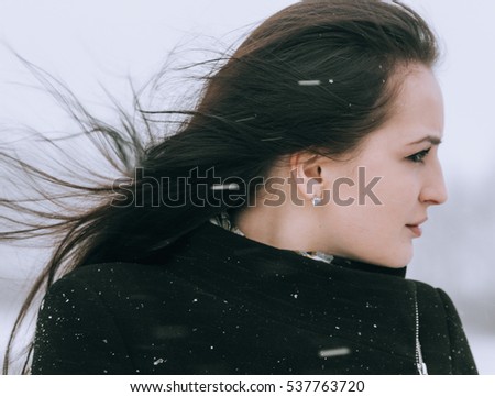 Woman winter snow nature portrait in black coat on road