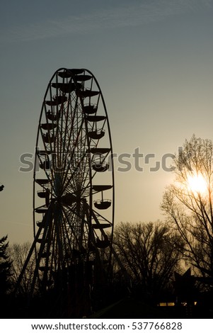 Illuminated ferris wheel in sunset