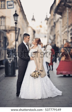 Wedding portrait of two lovers just married newlyweds photo in the middle of a big city, bouquet, wedding, couple
