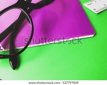 Eyeglasses on the colorful notebooks background school study wallpaper closeup view of education tools