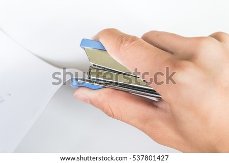 closeup of hand using stapler machine with paper - on white background