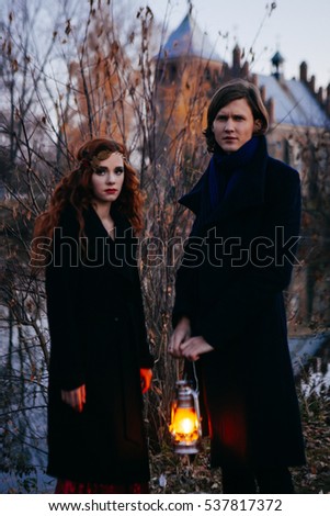 loving couple in beautiful autumn park with Vintage kerosene lamp