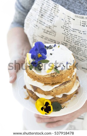 Small Spring Rustic Style Cake on White Service Plate Decorated, White Cream, Violets . Teapot, Flowers on Blade, Top View