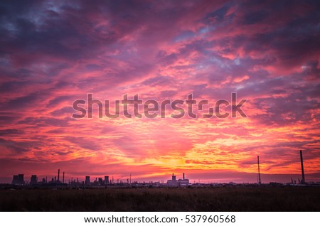Spectacular sunset with clouds in the sky. Beautiful sunset over a oil refinery. Royalty-Free Stock Photo #537960568