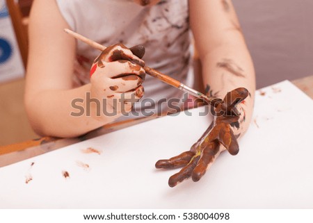 girl sitting at the table and draws paints 
