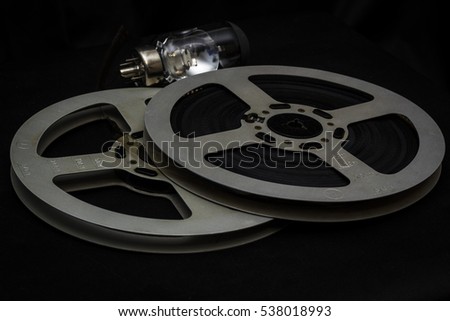 Vintage 8mm film and projector's lamp on a dark background