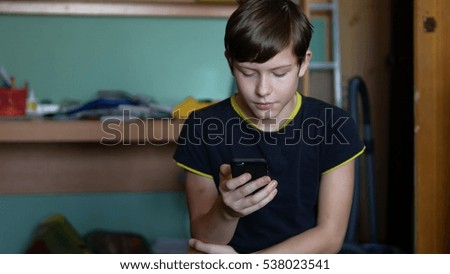 Teenage boy holding a smartphone online games web search social media