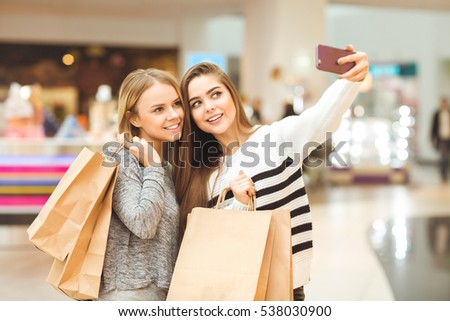 Online shopping. Beautiful young woman showing something on her smart phone to her handsome boyfriend while shopping together at the mall consumerism online shopping technology relationship concept 
