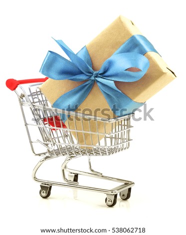 Gift with light blue bow in the shopping cart isolated on white background
