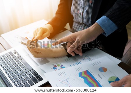 two business woman  and business man investment consultant analyzing company annual financial report balance sheet statement working with documents graphs. Concept picture of economy, market, money 