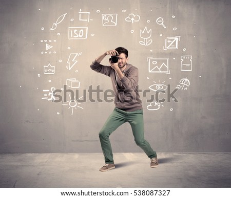 An amateur hobby photographer learning to use a professional digital camera with camera settings icons on the background wall concept