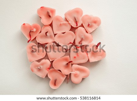 candles heart-shaped pink color lie on a white background
