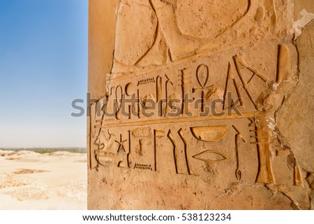 Mortuary temple of Hatshepsut in Deir el-Bahari. Ancient wall with the engraved Egyptian hieroglyphs. Deir el-Bahari, Egypt.