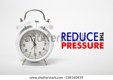 White old clock with text REDUCE THE PRESSURE Royalty-Free Stock Photo #538160839
