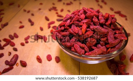 Dried goji berries in bowl and some goji on the kitchen table.
