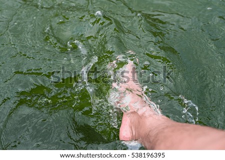 The girl bright foot moving in the water green color feeling relax on holiday.
