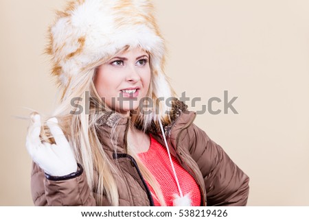 Clothing accessories, seasonal clothes concept. Woman wearing jacket and winter furry warm hat