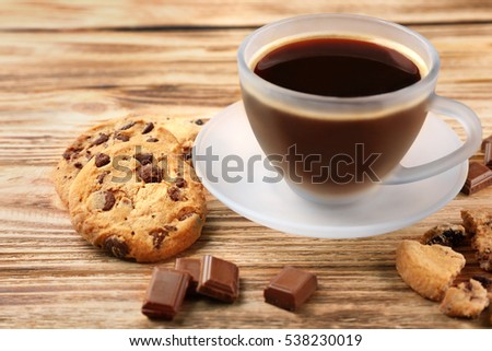 Tasty chocolate cookies with cup of hot coffee on wooden background