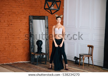 Portrait of beautiful young blond woman in bra and black pants