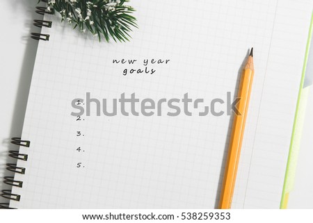 goals, Notebook and yellow pencil with conifer branch on a white background