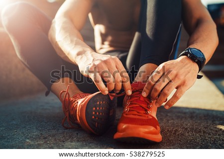 Young male jogger athlete training and doing workout outdoors in city. Royalty-Free Stock Photo #538279525