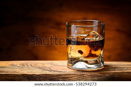 whiskey with ice on a wooden table Royalty-Free Stock Photo #538294273