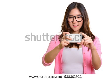 Young happy Asian woman taking picture with mobile phone