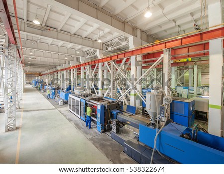 Industrial injection molding press machine for the manufacture of plastic parts using polymers in the management of worker Royalty-Free Stock Photo #538322674