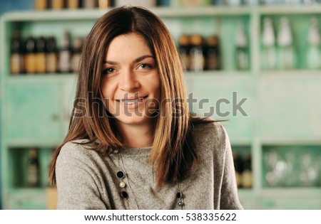 Young woman smiling in a pub Royalty-Free Stock Photo #538335622