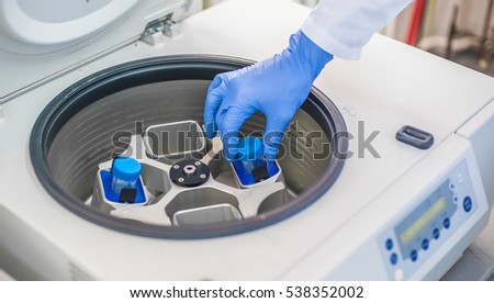 Technician loading a sample to centrifuge machine in the medical or scientific laboratory Royalty-Free Stock Photo #538352002