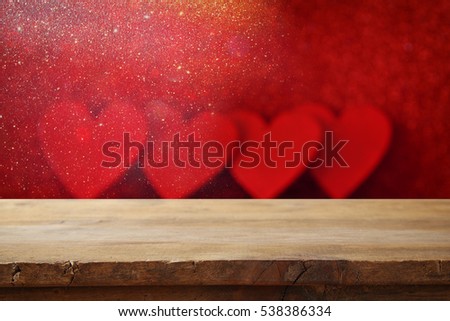 Valentines day concept. Empty wooden table in front of glitter red hearts background. For product display montage